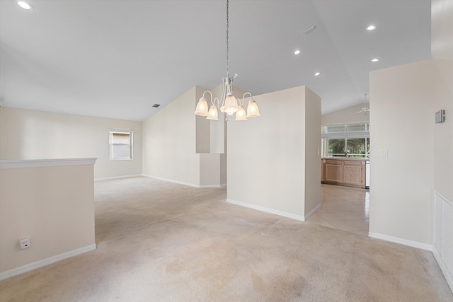 empty room with sink, light colored carpet, lofted ceiling, and an inviting chandelier