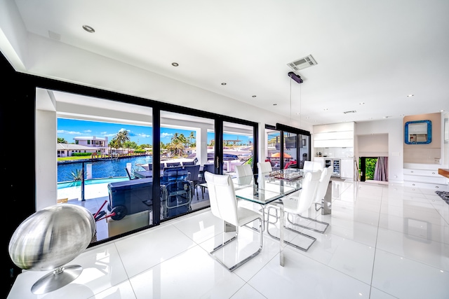 dining area featuring a water view and light tile patterned floors