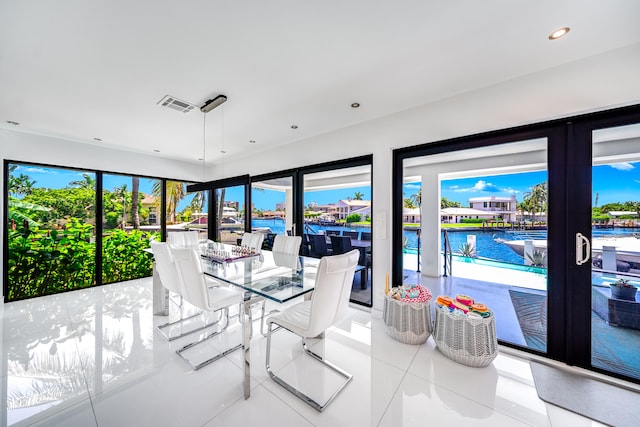 tiled dining area with plenty of natural light and a water view