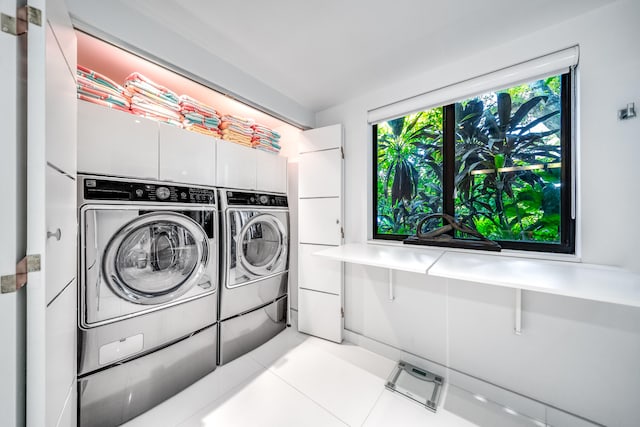 laundry room with independent washer and dryer and light tile patterned flooring