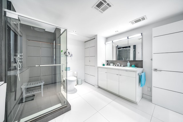 bathroom featuring tile patterned flooring, vanity, tasteful backsplash, and toilet