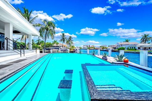 view of pool with a water view and a patio