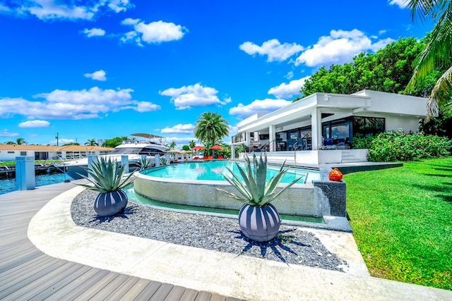 view of swimming pool featuring a lawn and a water view