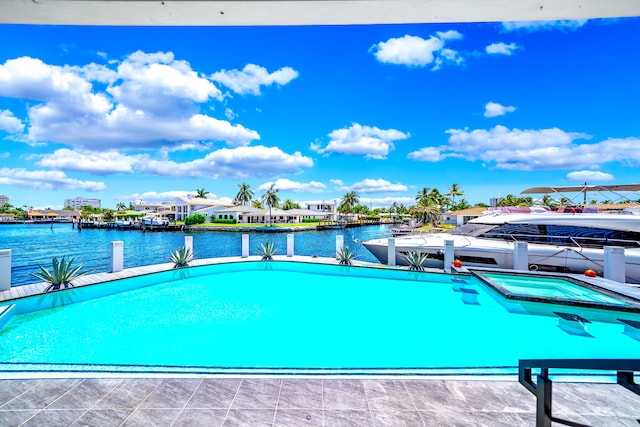 view of pool featuring an in ground hot tub and a water view