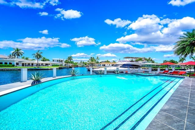 view of swimming pool with a water view and a boat dock