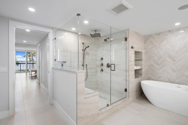 bathroom featuring tile patterned flooring and separate shower and tub