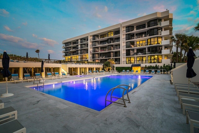 pool at dusk featuring a patio area