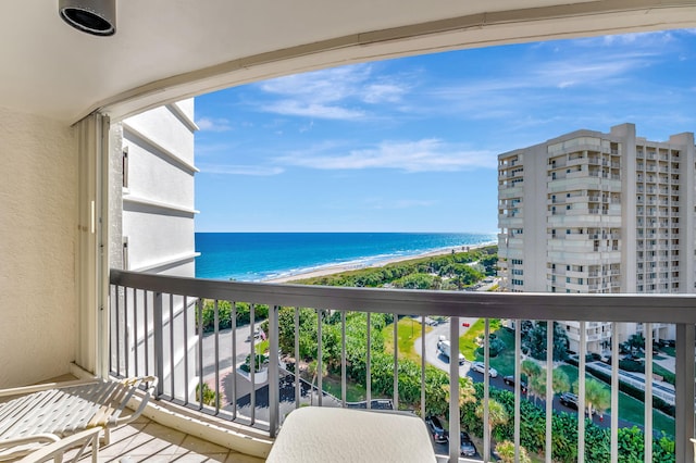 balcony featuring a view of the beach and a water view