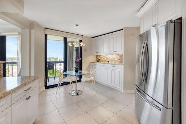 4545 N Ocean Blvd Unit 11C, Boca Raton, FL 33431 - kitchen featuring freestanding refrigerator, decorative backsplash, a chandelier, white cabinets, and light stone counters