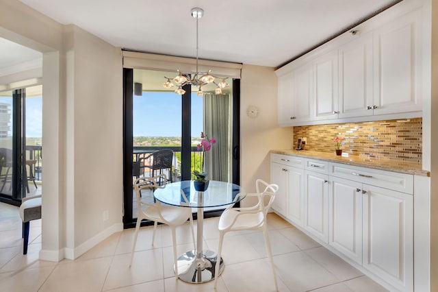 4545 N Ocean Blvd Unit 11C, Boca Raton, FL 33431 - dining area with light tile patterned flooring, baseboards, a chandelier, and a healthy amount of sunlight