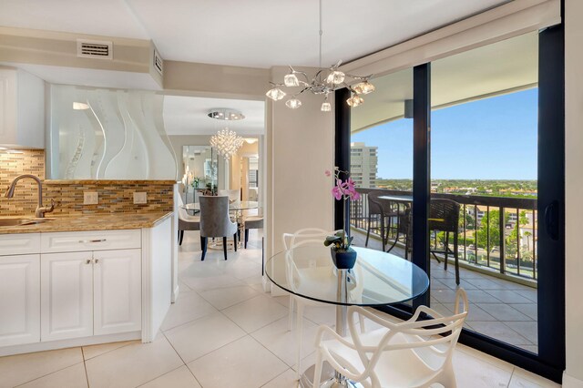 dining space featuring a notable chandelier, light tile patterned floors, and a wealth of natural light