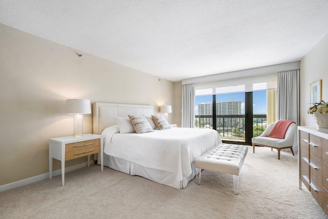 bedroom with a textured ceiling, light carpet, and access to outside