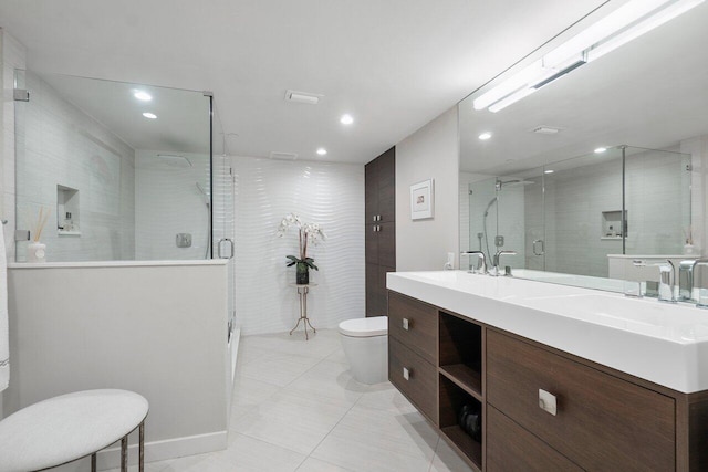 bathroom featuring tile patterned floors, vanity, toilet, and walk in shower