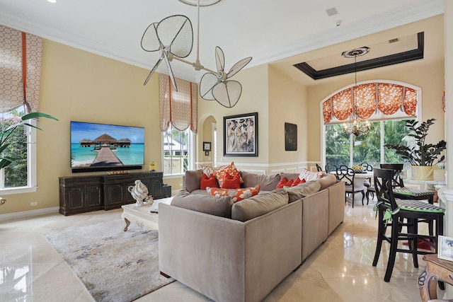 living room with a chandelier, a healthy amount of sunlight, and ornamental molding