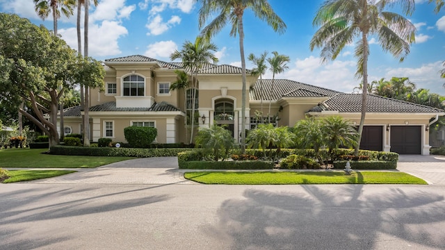 mediterranean / spanish house with a garage and a front yard