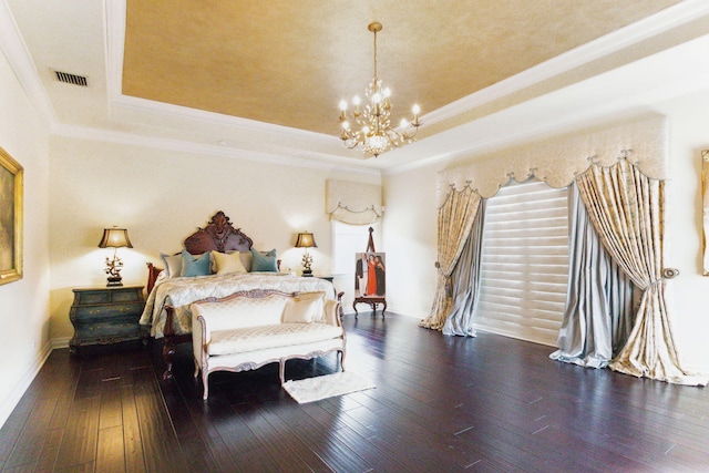 bedroom featuring a raised ceiling, ornamental molding, dark wood-type flooring, and an inviting chandelier