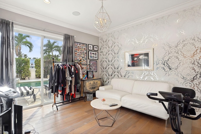 living room with a chandelier, light wood-type flooring, and ornamental molding