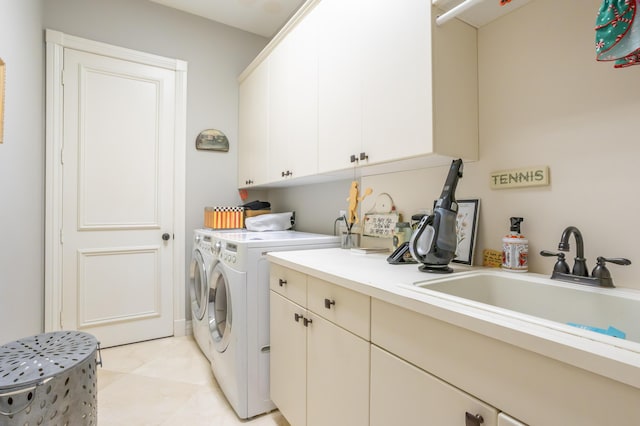 laundry room featuring washer and clothes dryer, light tile patterned floors, cabinets, and sink