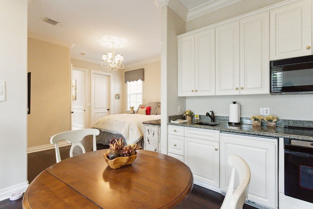 interior space with an inviting chandelier, sink, crown molding, and dark wood-type flooring