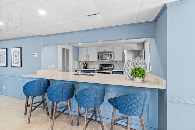 kitchen with sink, backsplash, a breakfast bar area, and appliances with stainless steel finishes