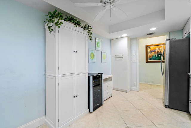 kitchen with white cabinetry, stainless steel fridge, beverage cooler, light tile patterned floors, and ceiling fan