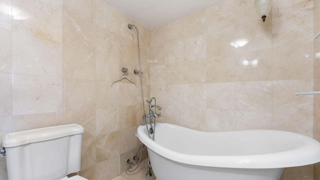 bathroom with toilet, tile walls, and a bathing tub