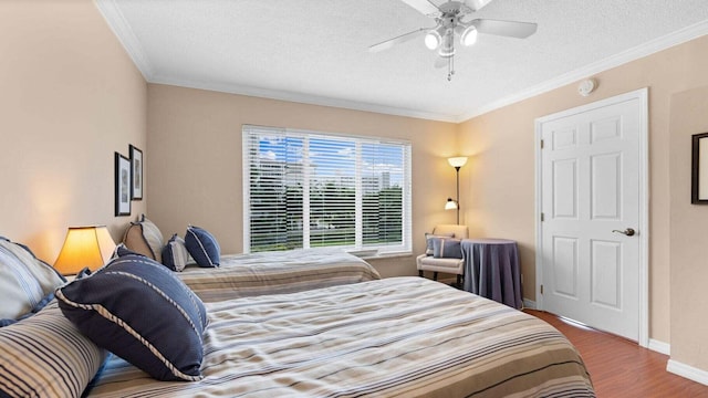 bedroom featuring hardwood / wood-style floors, ceiling fan, crown molding, and a textured ceiling