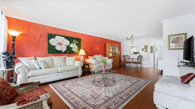 living room featuring a notable chandelier, crown molding, and dark wood-type flooring