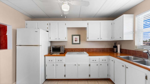 kitchen with white cabinetry and white fridge