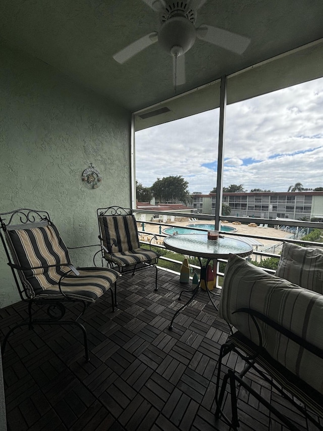 view of patio with ceiling fan and a balcony