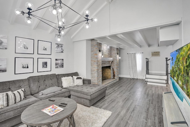 living room featuring a fireplace, beam ceiling, hardwood / wood-style flooring, and a notable chandelier