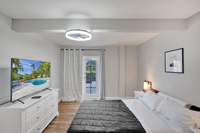 bedroom featuring beam ceiling and light wood-type flooring