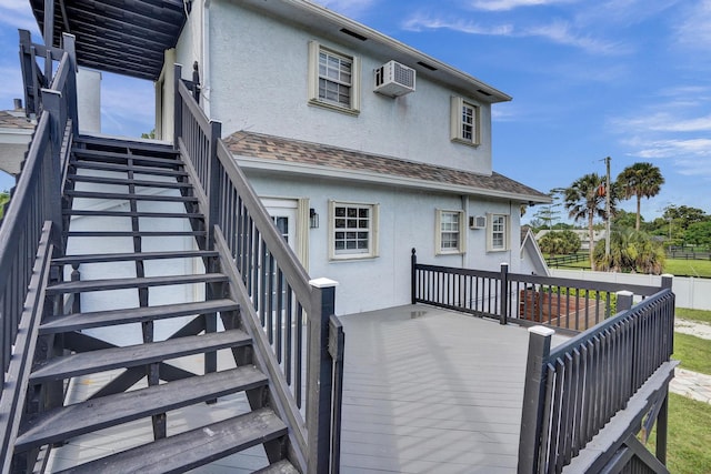 rear view of house with a wall mounted air conditioner