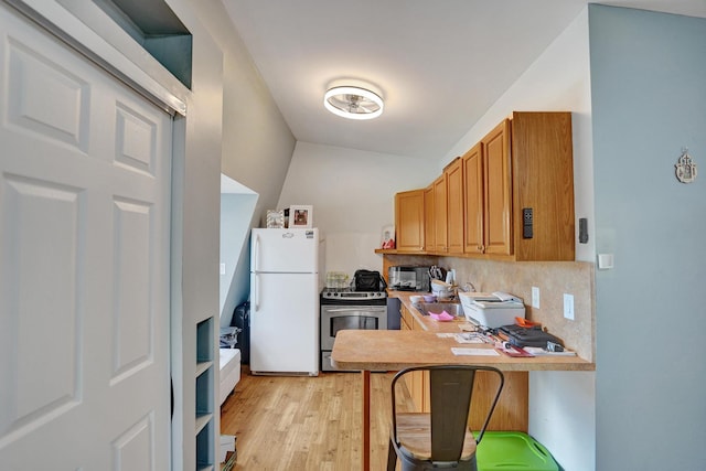 kitchen featuring backsplash, vaulted ceiling, white refrigerator, light hardwood / wood-style floors, and stainless steel electric range