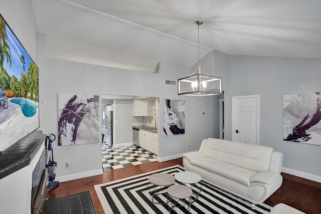 living room featuring sink, dark hardwood / wood-style floors, vaulted ceiling, and a notable chandelier