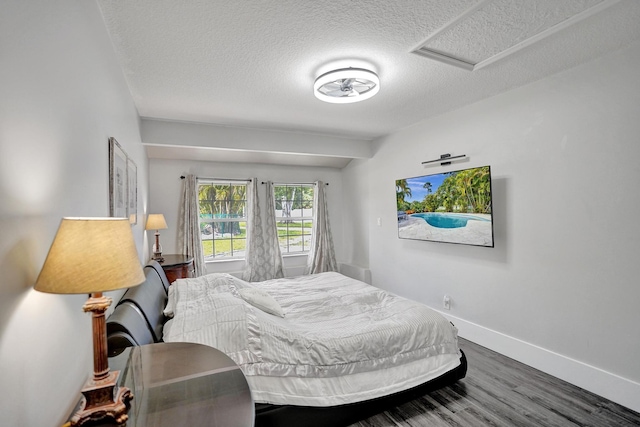 bedroom with a textured ceiling and dark wood-type flooring