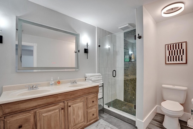 bathroom featuring hardwood / wood-style flooring, vanity, toilet, and a shower with shower door