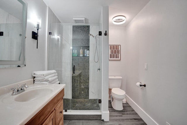 bathroom featuring an enclosed shower, vanity, toilet, and wood-type flooring