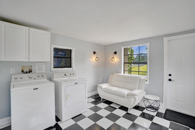 clothes washing area featuring cabinets and independent washer and dryer