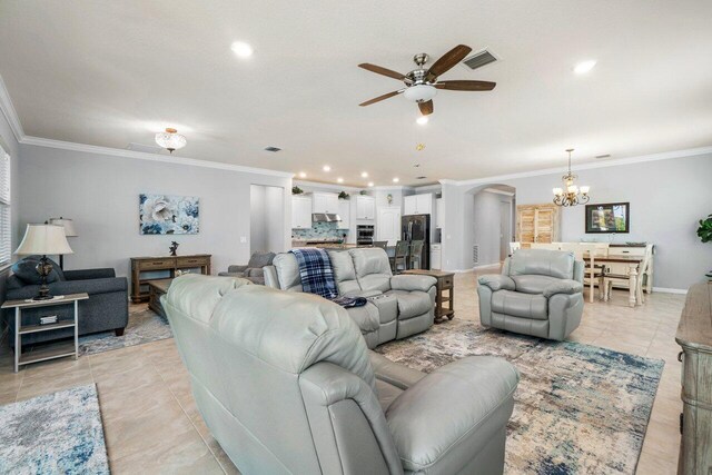 living area featuring baseboards, arched walkways, and crown molding