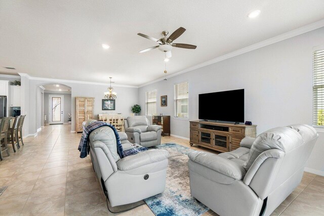 living area featuring arched walkways, light tile patterned floors, visible vents, and crown molding