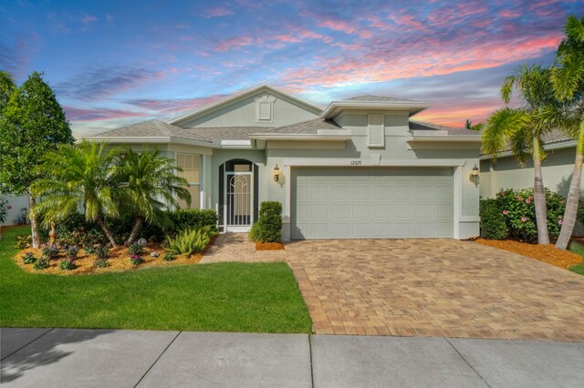 view of front of home with a garage, decorative driveway, and stucco siding