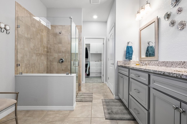 bathroom featuring tile patterned flooring, vanity, and a shower with shower door