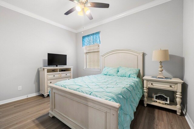 workout room featuring light wood-type flooring, ceiling fan, baseboards, and crown molding