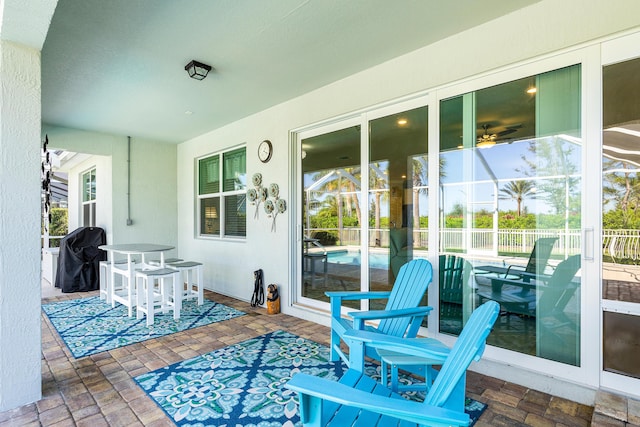 view of patio with area for grilling and a lanai