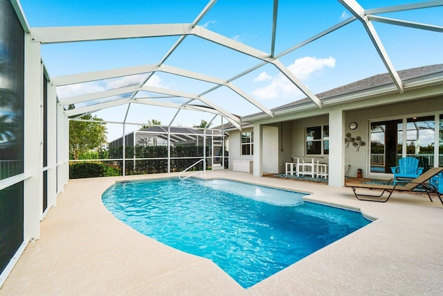 pool with glass enclosure and a patio