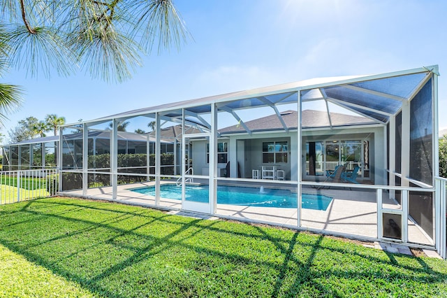 view of swimming pool with glass enclosure, a patio area, and a lawn