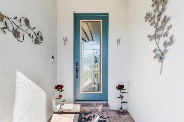 entrance to property featuring stucco siding