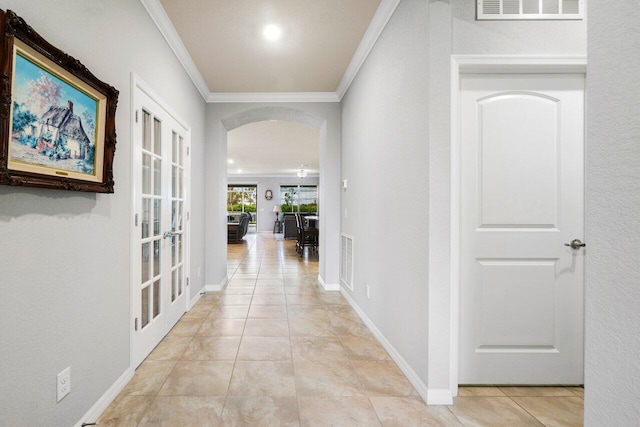 hall with arched walkways, french doors, visible vents, and crown molding