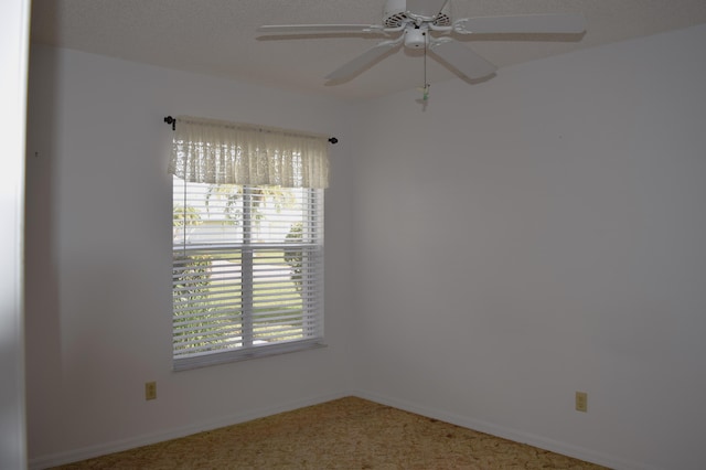 carpeted spare room with plenty of natural light and ceiling fan